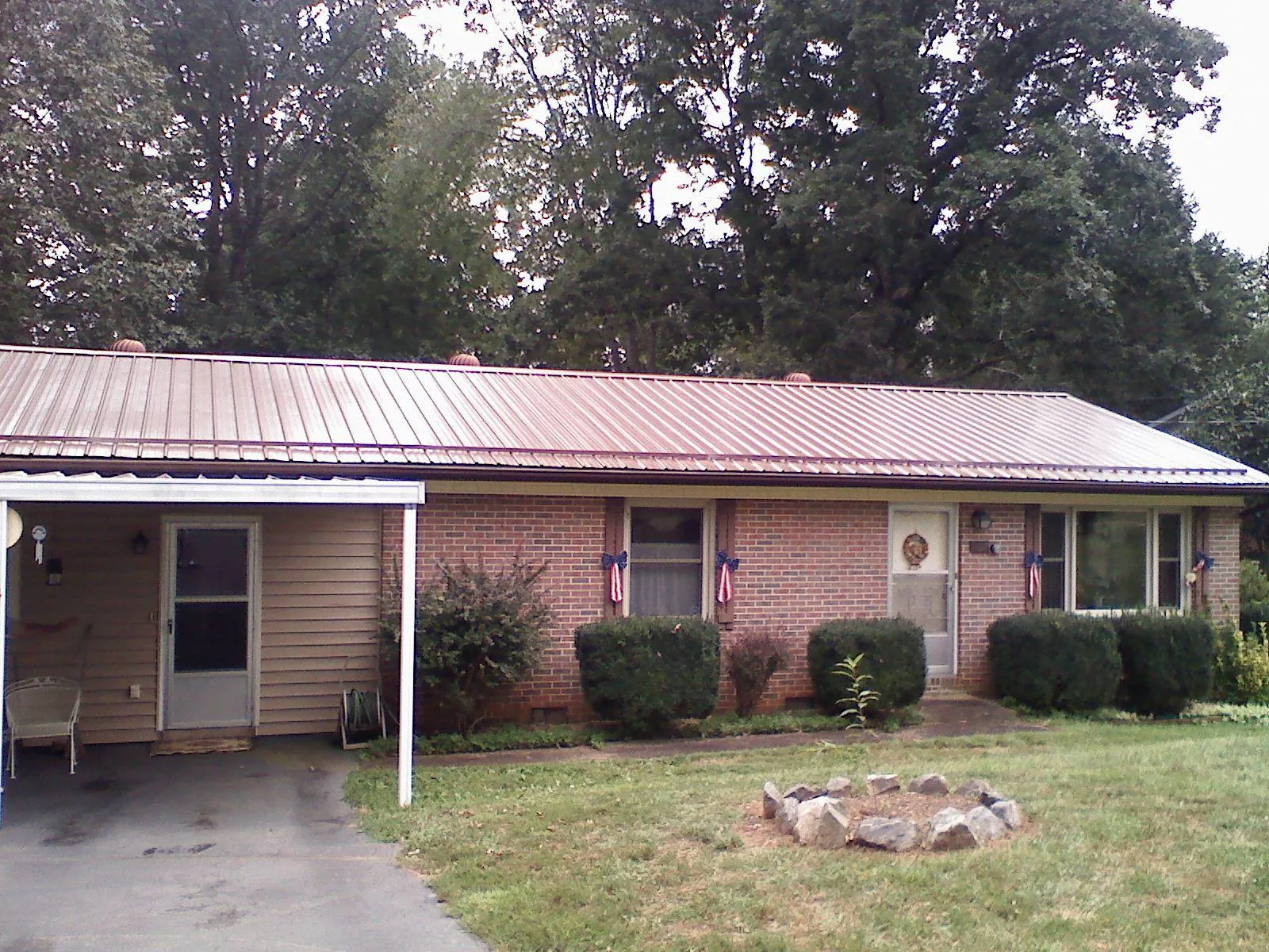 Bronze metal roof and carport on a brick ranch home — Roof Repair work by our crew in Alleyton